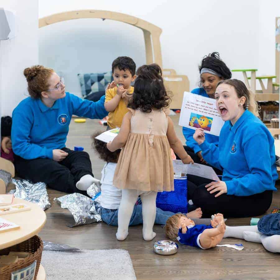 header-nursery-vs-school Childcare activities at Monkey Puzzle Day Nurseries with young children and caregivers engaging in storytelling and play, promoting early childhood development.