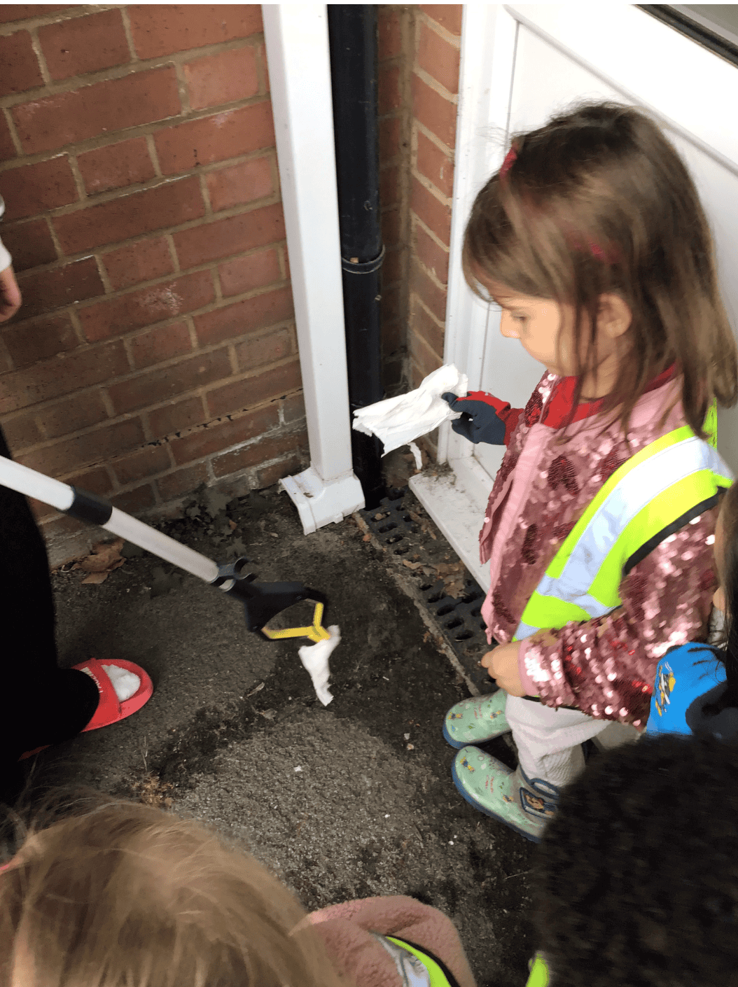 Preschool girl helping pick up rubbish
