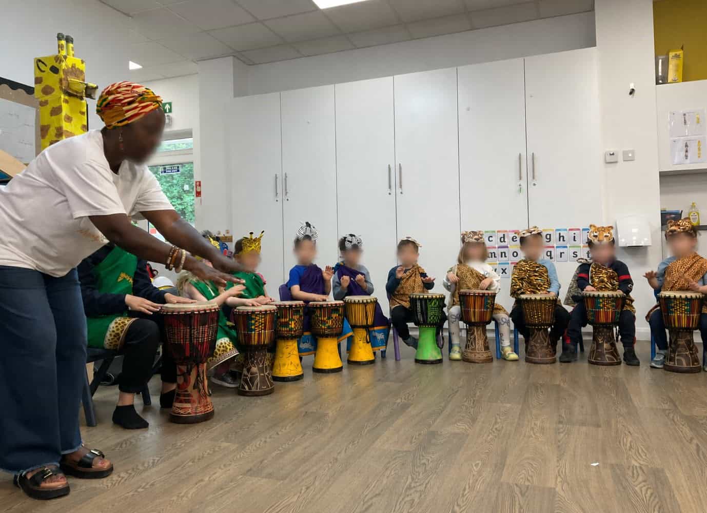 Children being showed how to play the African drums